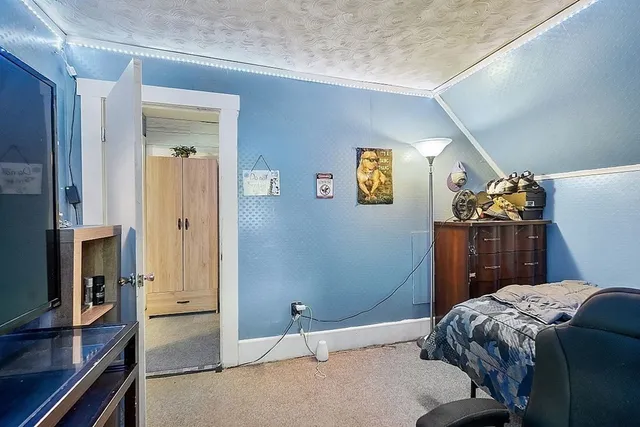 a bedroom with a bed and a flat tv screen on the dresser