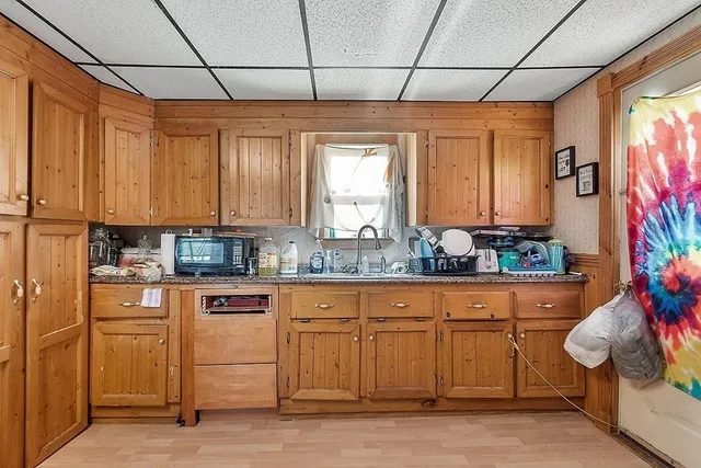 a kitchen with stainless steel appliances granite countertop a sink window and cabinets