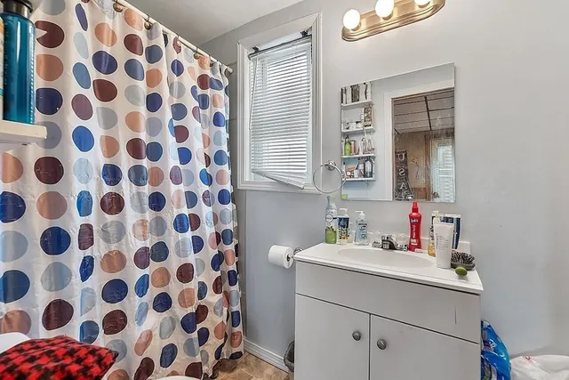 a bathroom with a sink mirror and shower