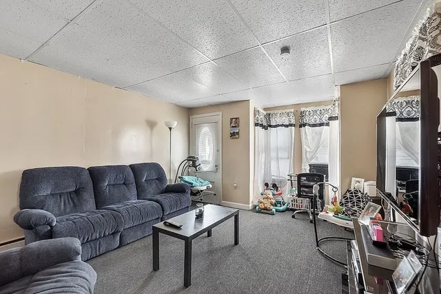 a living room with furniture ceiling fan and a window