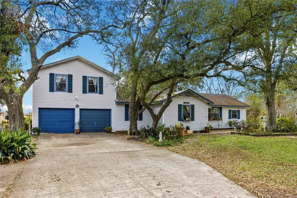a front view of house with yard and trees around