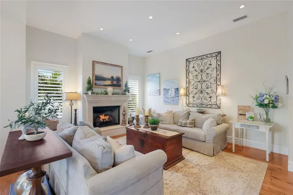 a living room with furniture kitchen view and a wooden floor