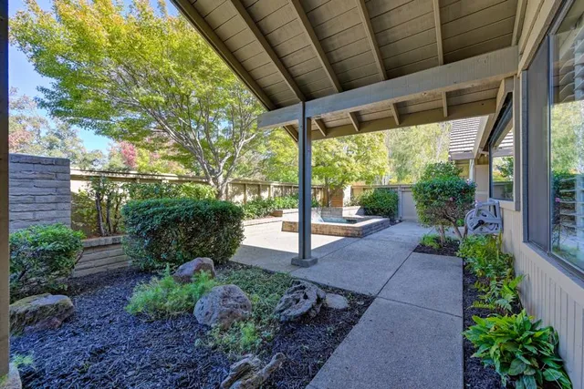 a view of a patio with table and chairs with wooden fence and plants