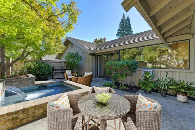 a view of a house with backyard and sitting area