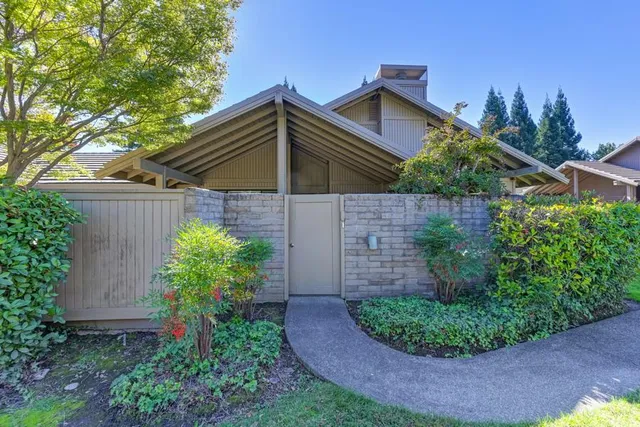 a view of a backyard with plants and entertaining space