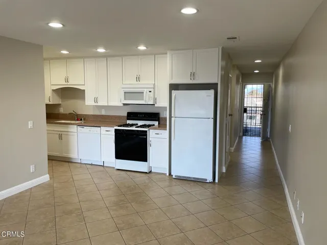 a kitchen with granite countertop a refrigerator and a sink