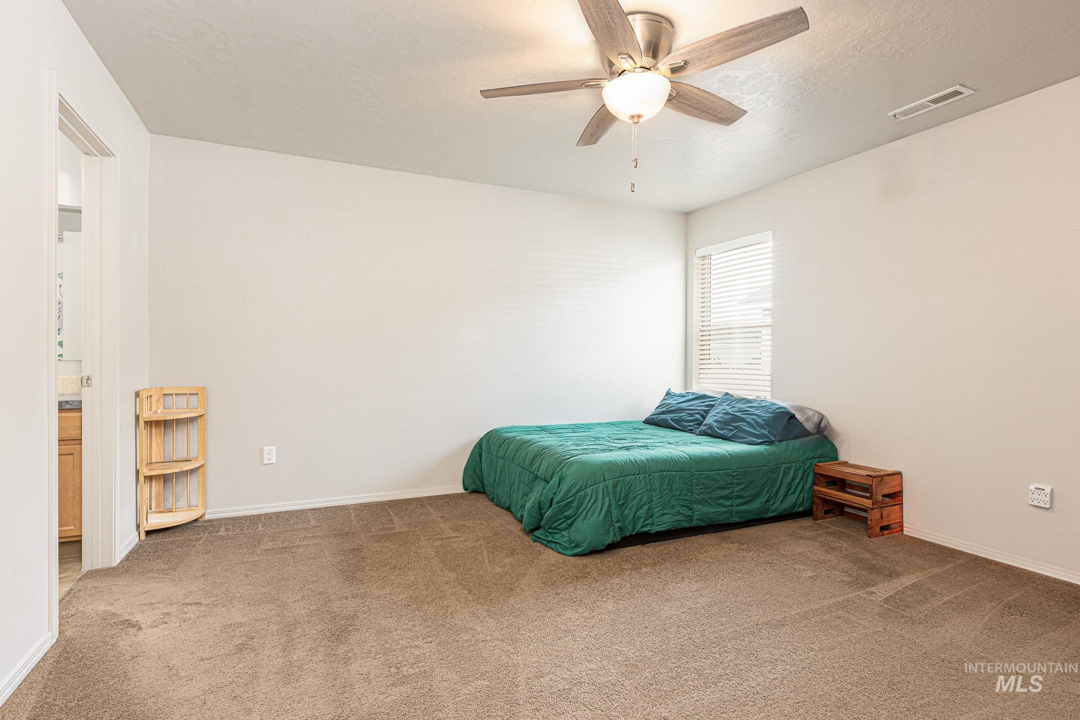 643 North Manship Avenue Meridian, ID 83642 - Photo 13 of 32 Bedroom with carpet flooring, ceiling fan, and a textured ceiling