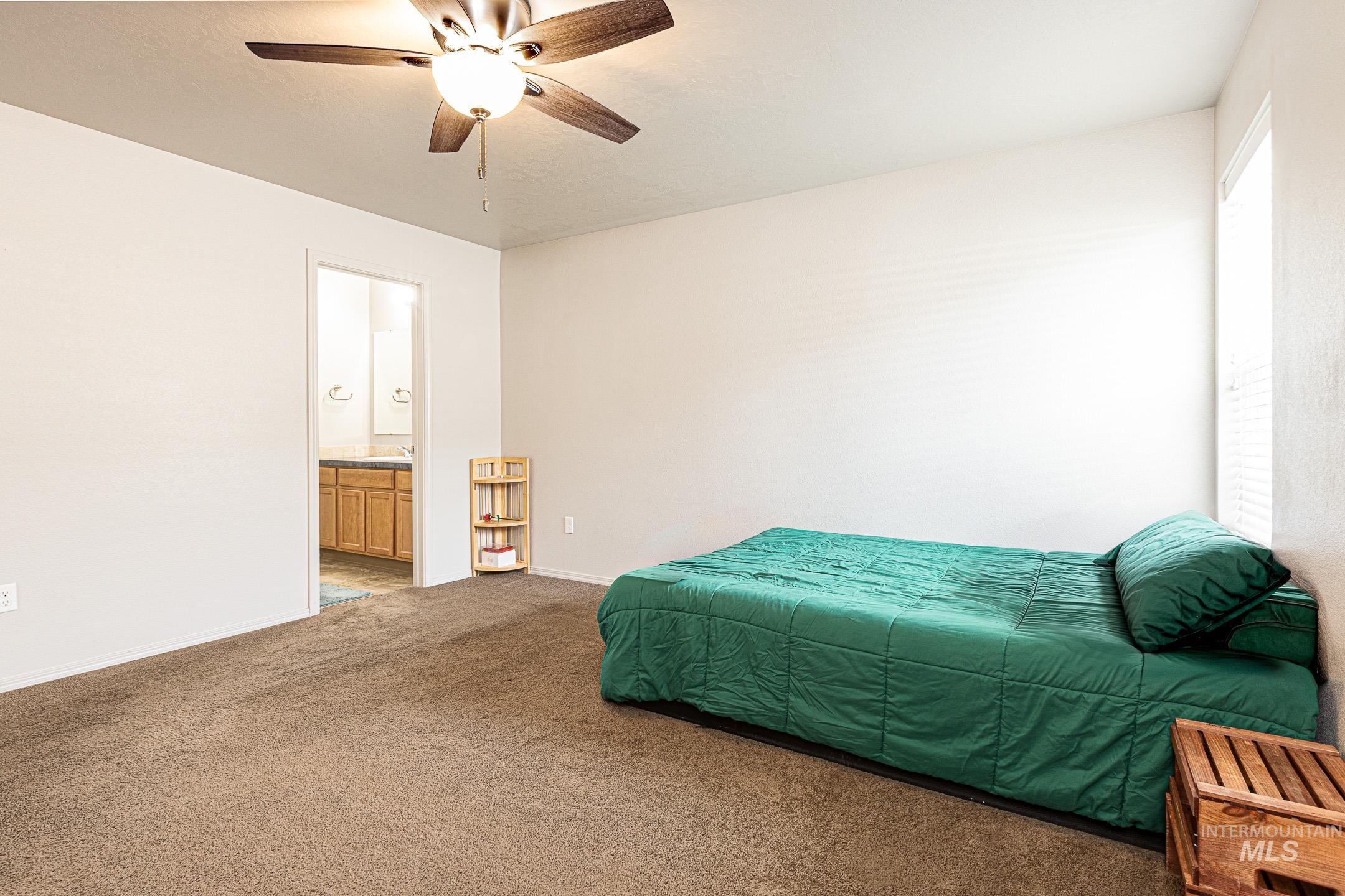 643 North Manship Avenue Meridian, ID 83642 - Photo 14 of 32 Carpeted bedroom featuring a ceiling fan and connected bathroom