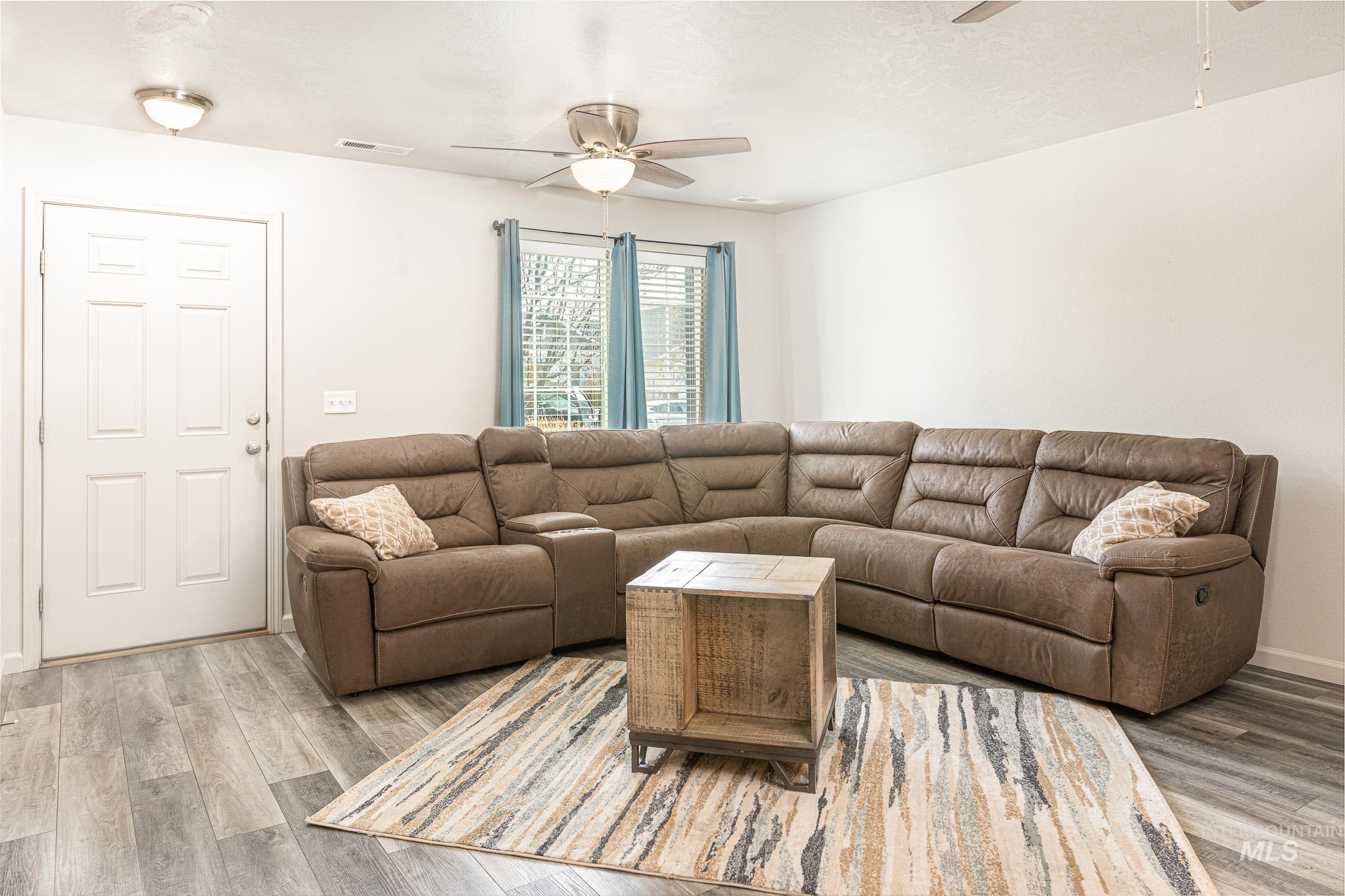 643 North Manship Avenue Meridian, ID 83642 - Photo 2 of 32 Living area featuring ceiling fan, light wood-type flooring, and a textured ceiling