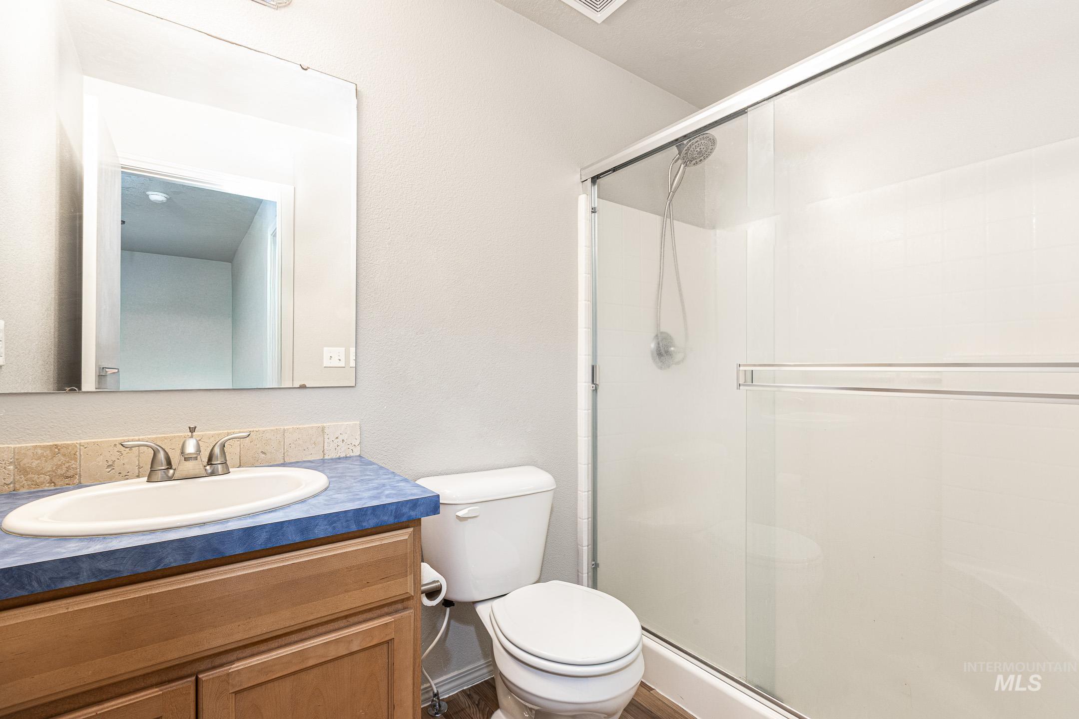 643 North Manship Avenue Meridian, ID 83642 - Photo 22 of 32 Full bathroom featuring a shower stall, vanity, and a textured wall