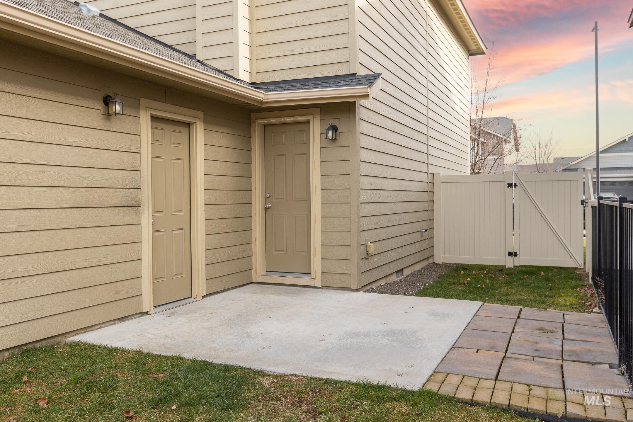 643 North Manship Avenue Meridian, ID 83642 - Photo 30 of 32 Exterior entry at dusk featuring a gate, a patio area, and roof with shingles