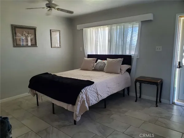 a bedroom with a bed lamp and a window