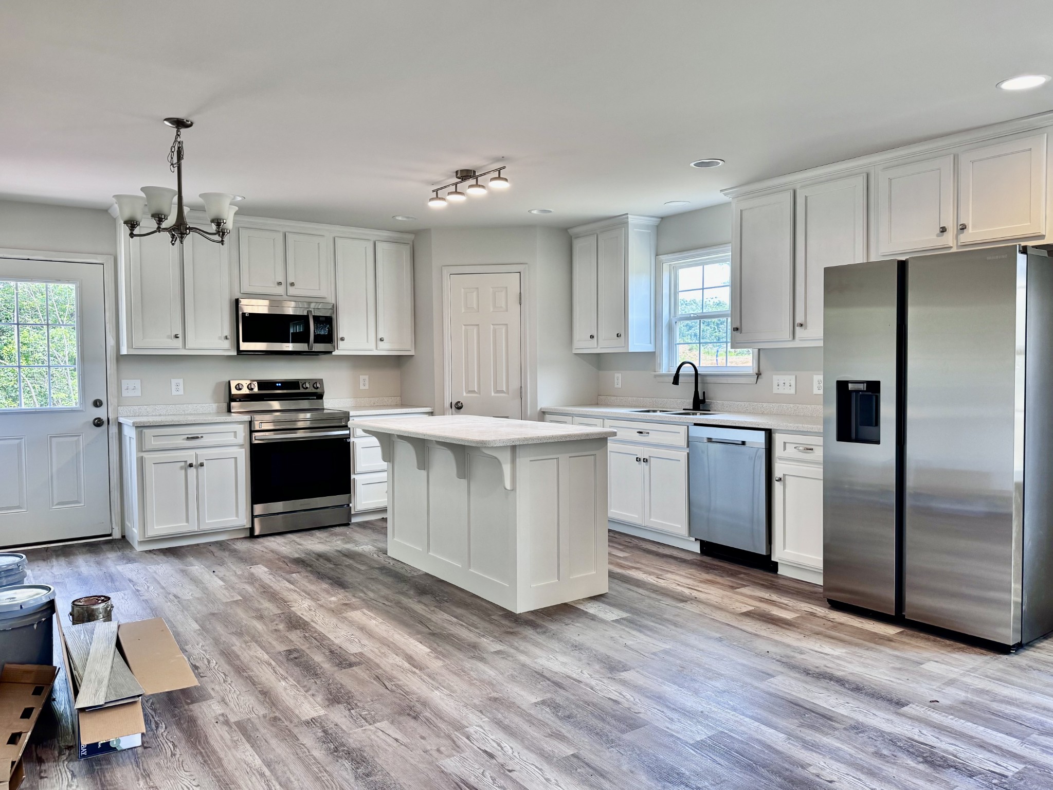 1122 Brannon Road Lawrenceburg, TN 38464 - Photo 3 of 21 a kitchen with stainless steel appliances granite countertop a stove top oven a refrigerator and white cabinets with wooden floor