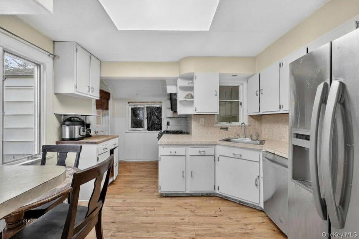 560 Locust Avenue Port Chester, NY 10573 - Photo 14 of 35 a kitchen with stainless steel appliances granite countertop a table chairs sink refrigerator and cabinets