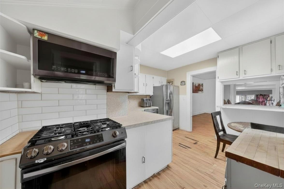 560 Locust Avenue Port Chester, NY 10573 - Photo 16 of 35 a kitchen with a stove a microwave and refrigerator
