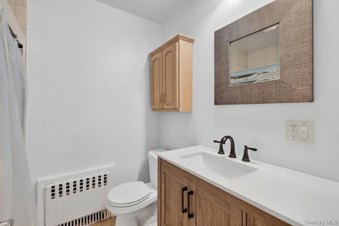 560 Locust Avenue Port Chester, NY 10573 - Photo 17 of 35 a bathroom with a toilet a sink and mirror
