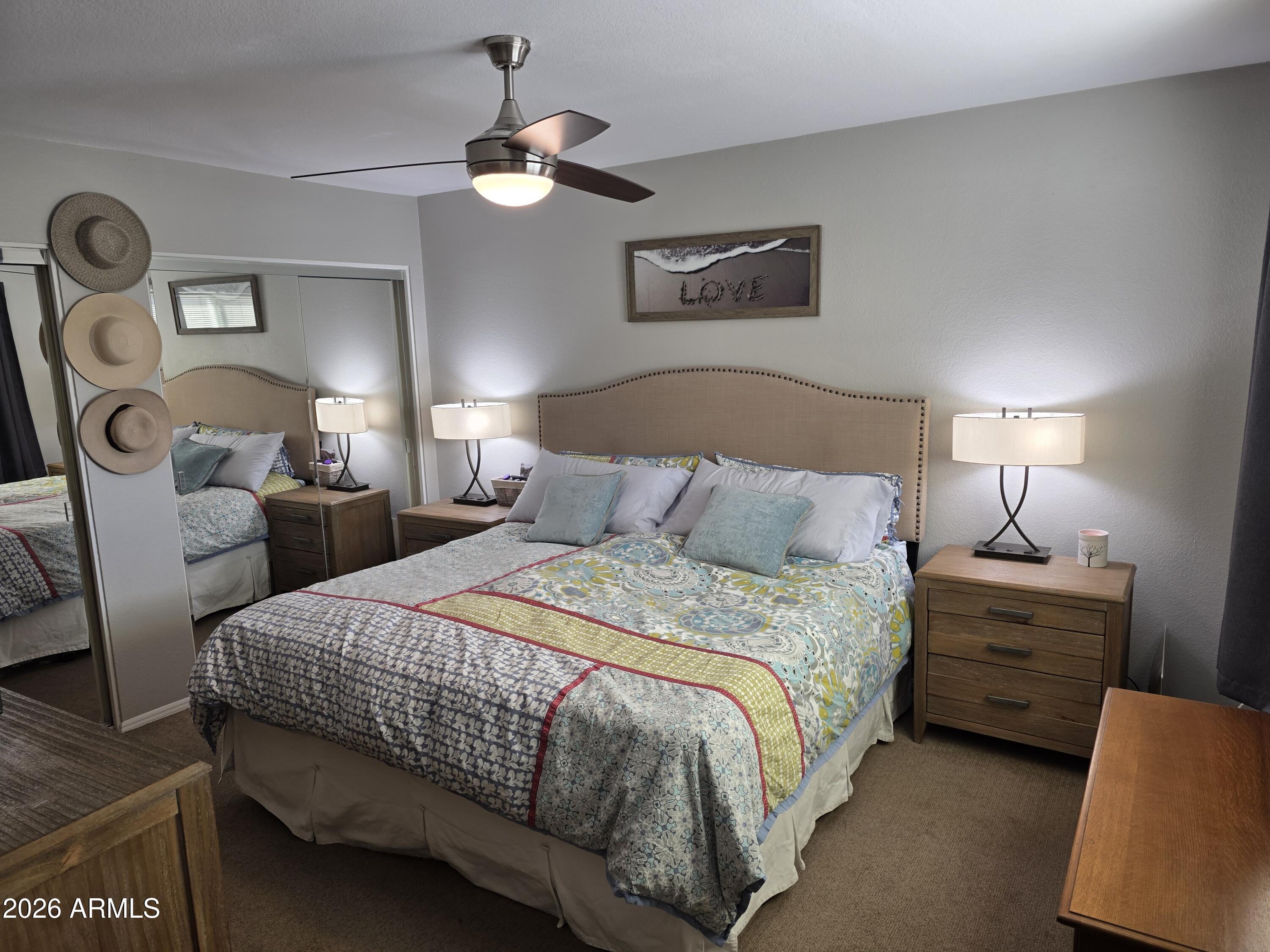 222 West Brown Road, Unit 107 Mesa, AZ 85201 - Photo 12 of 24 a bedroom with bed and a chandelier