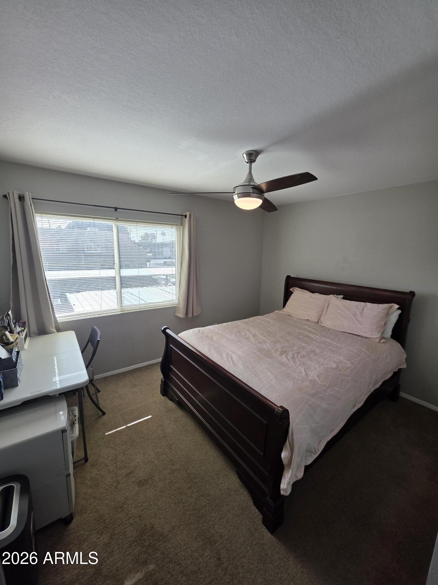 222 West Brown Road, Unit 107 Mesa, AZ 85201 - Photo 13 of 24 a bed sitting in a bedroom next to a window