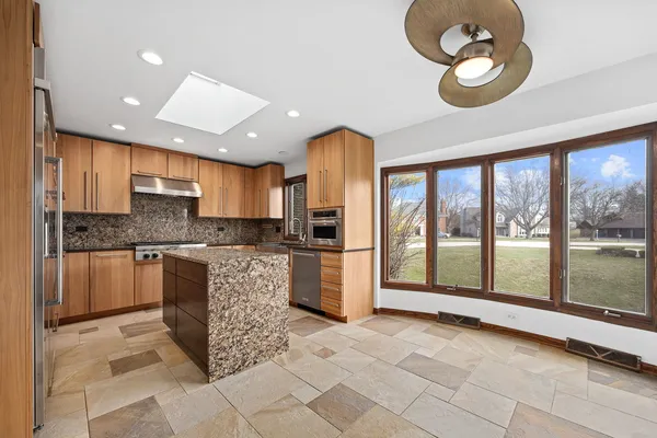 a large kitchen with a large window cabinets and stainless steel appliances