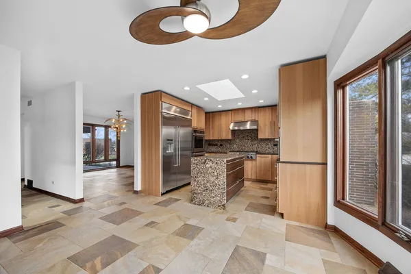 a kitchen with stainless steel appliances granite countertop a refrigerator and a stove top oven