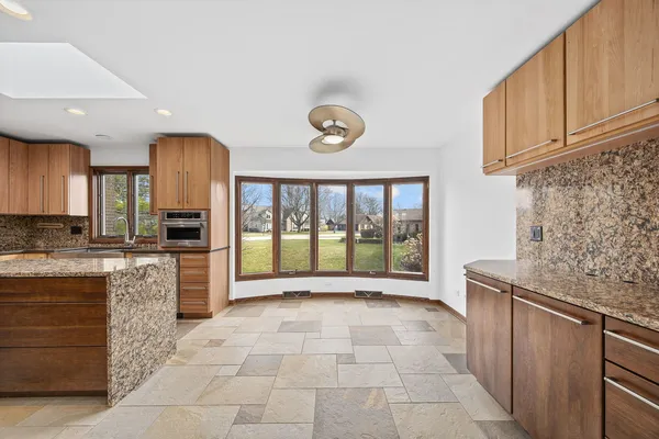 a large kitchen with stainless steel appliances granite countertop a stove a sink and a refrigerator