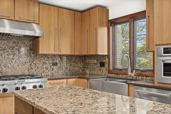 a kitchen with stainless steel appliances granite countertop a stove a sink and a microwave