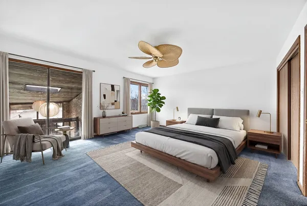 a living room with a bed furniture and a large window