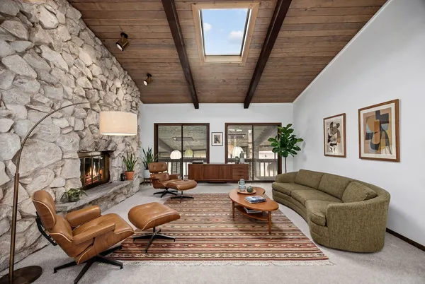 a living room with furniture a fireplace and a floor to ceiling window