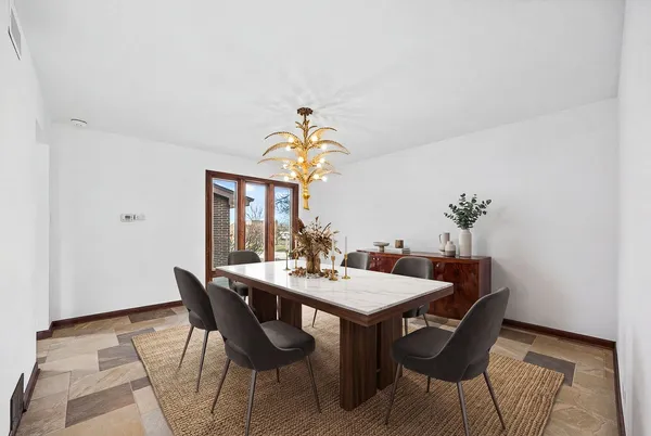 a dining room with furniture potted plants and wooden floor