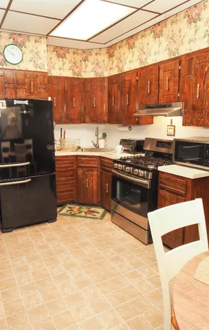 a kitchen with stainless steel appliances kitchen island granite countertop a stove and a sink