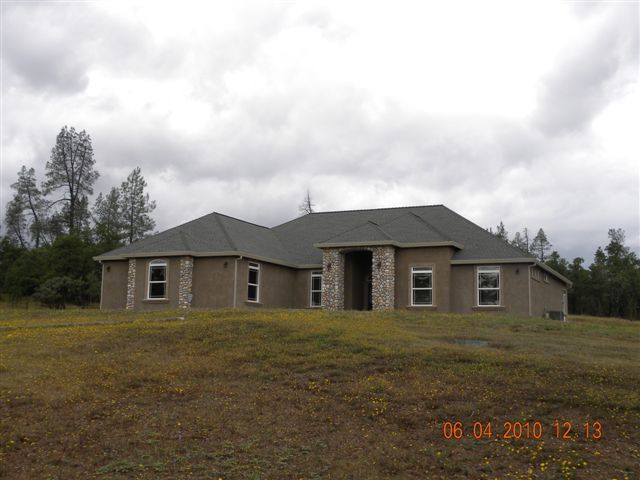12280 Intermountain Road Redding, CA 96003 - Photo 2 of 45 a front view of a house with a garden