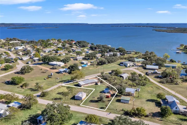 an aerial view of ocean and residential houses with outdoor space