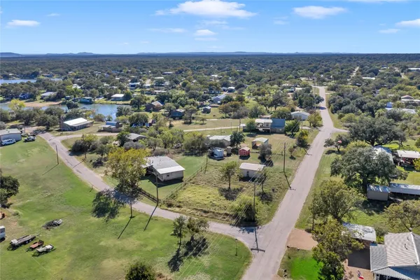 an aerial view of residential houses with outdoor space and trees