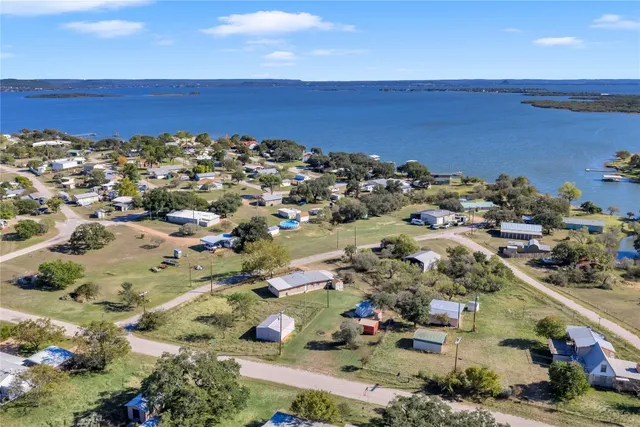 an aerial view of ocean and residential houses with outdoor space