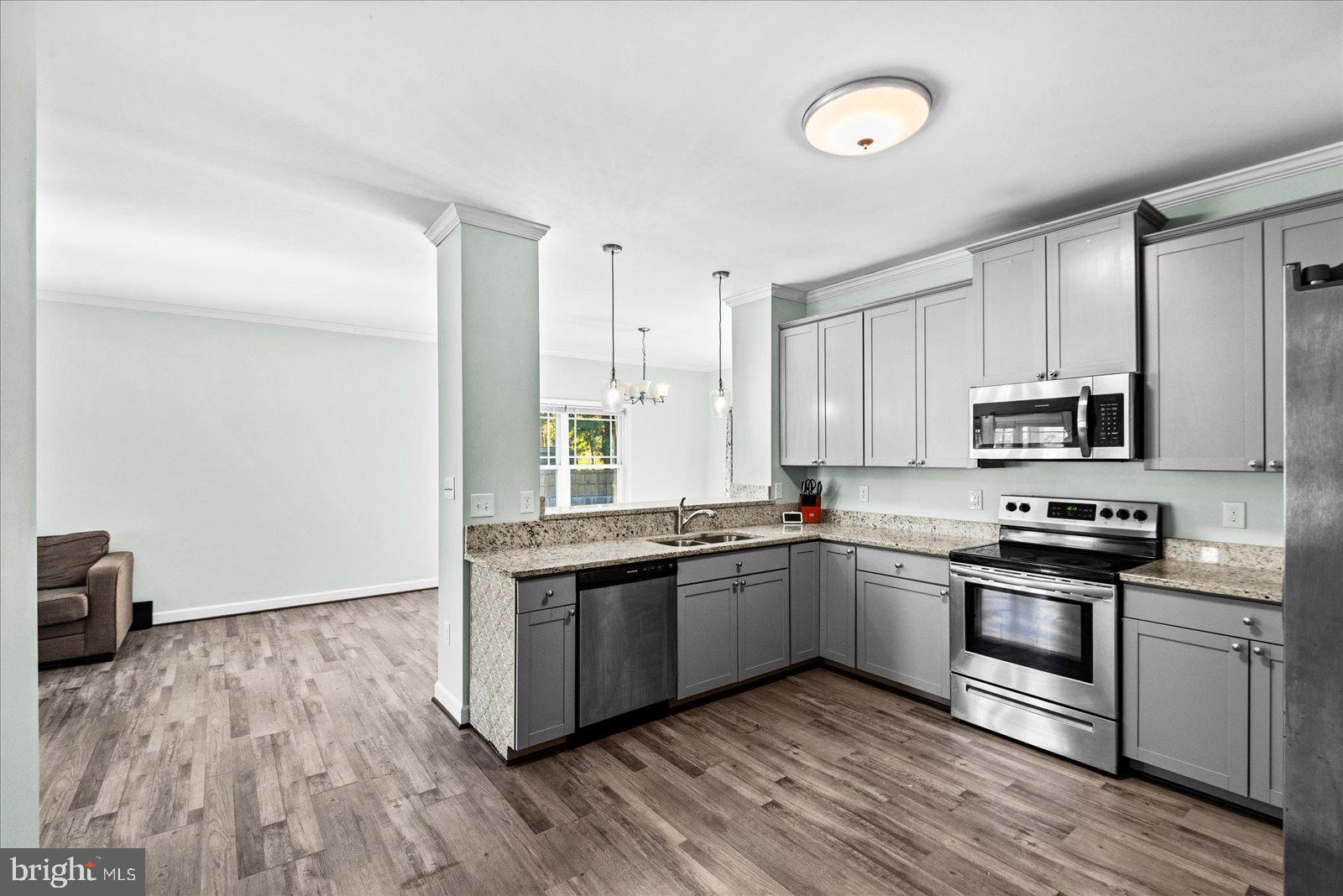 88 Brooks Drive Colonial Beach, VA 22443 - Photo 12 of 36 a kitchen with stainless steel appliances granite countertop a stove top oven a sink and dishwasher with wooden floor