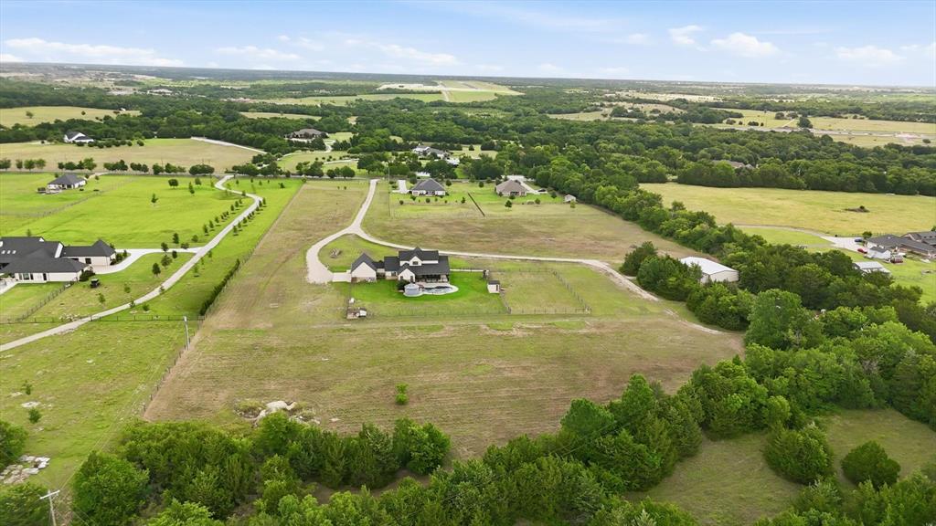 6020 Honeysuckle Road Midlothian, TX 76065 - Photo 38 of 39 Expansive property featuring a large residence, swimming pool, gravel driveway, and surrounding green spaces