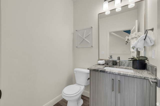 4016 South Burch Way Ogden, UT 84405 - Photo 7 of 30 Bathroom featuring a wood-finish vanity with a stone countertop, an undermount sink, and a framed mirror