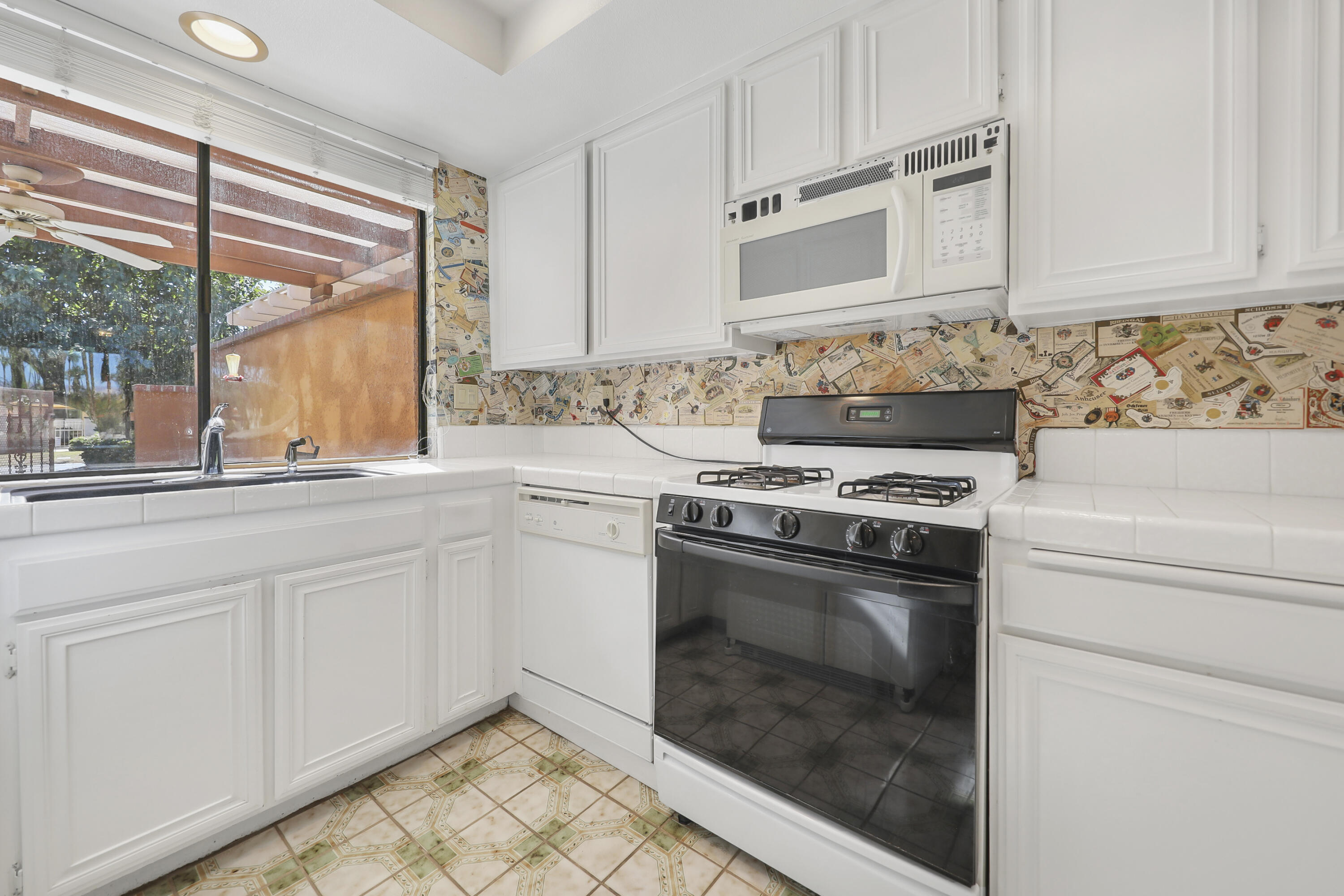2 Valencia Drive Rancho Mirage, CA 92270 - Photo 5 of 39 a kitchen with granite countertop white cabinets and white appliances