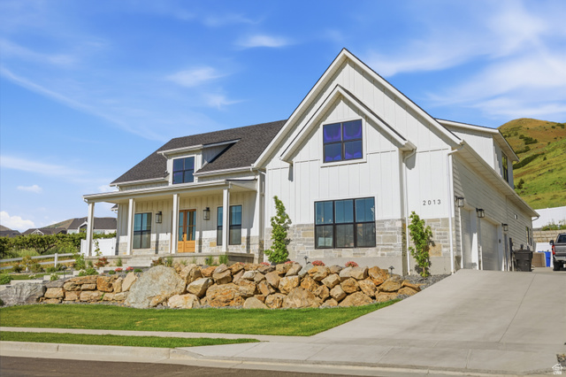 2013 South 100 West Perry, UT 84302 - Photo 7 of 49 Modern farmhouse exterior with a covered front porch, board and batten siding, and stone accents