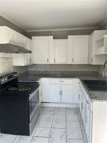 a kitchen with granite countertop white cabinets and appliances