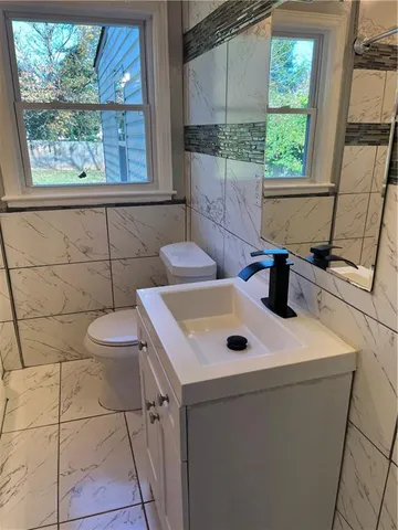 a bathroom with a sink a toilet and a window