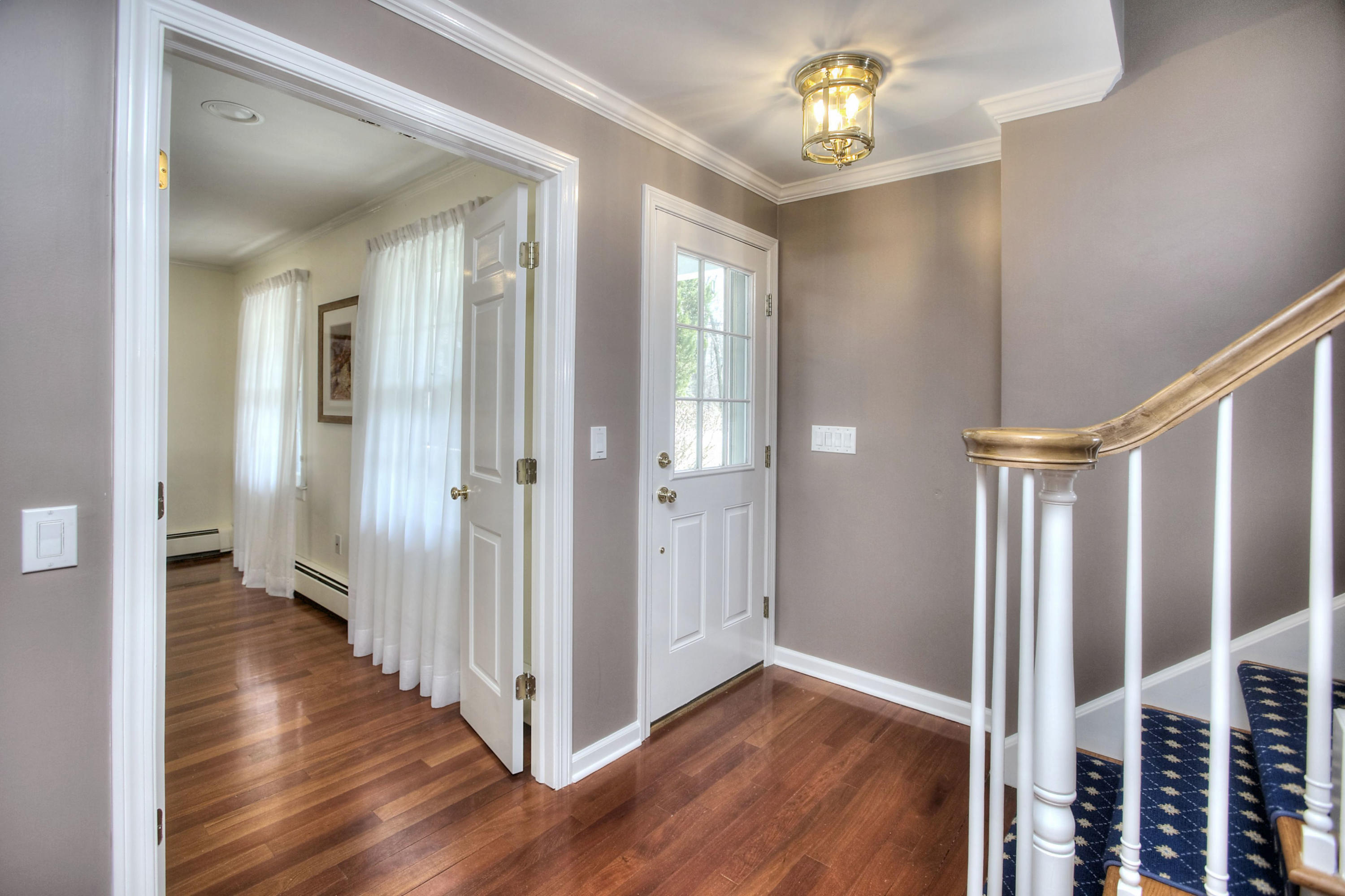 16 Arrowhead Road Wilton, CT 06897 - Photo 24 of 37 a view of a hallway with wooden floor and chandelier