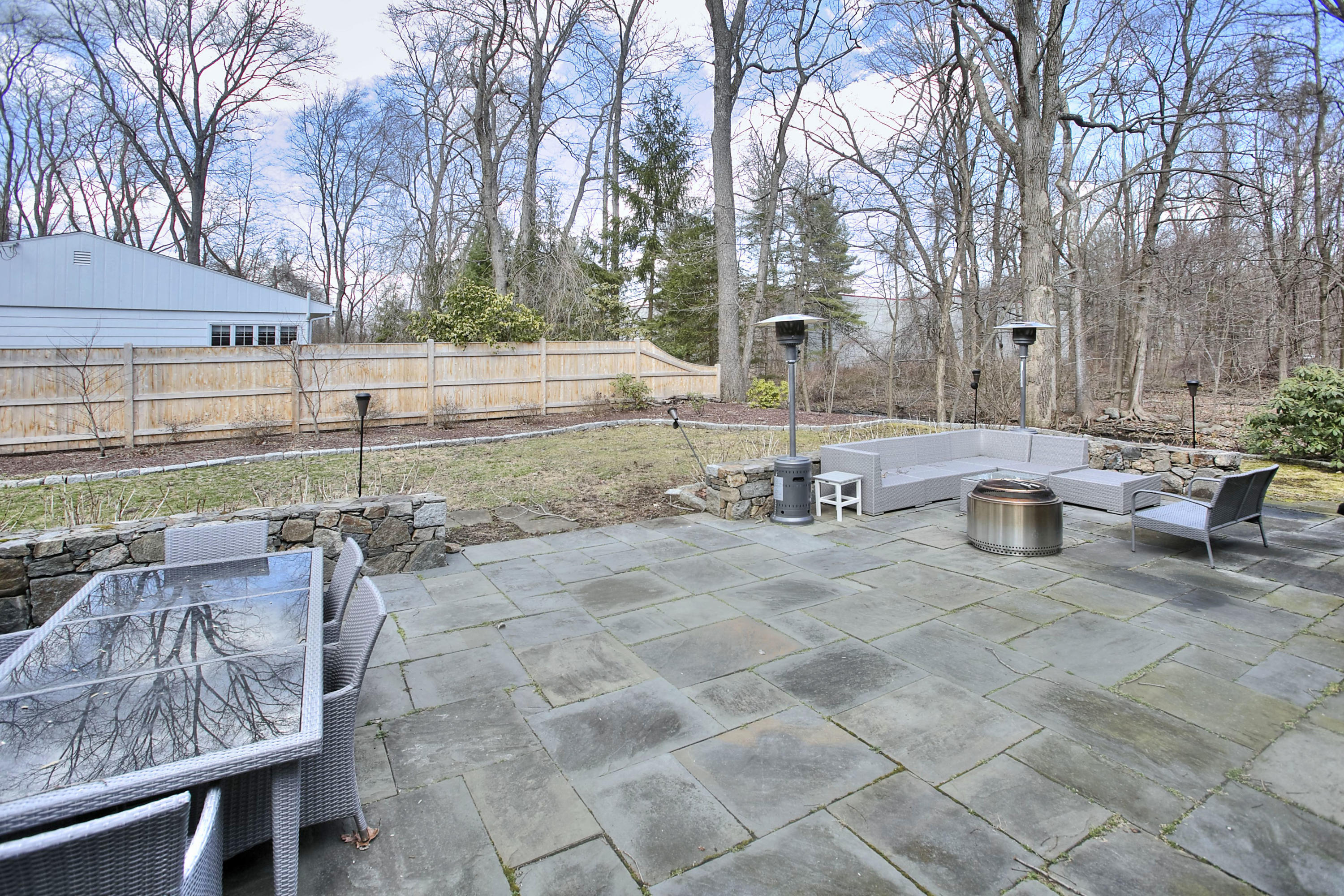 16 Arrowhead Road Wilton, CT 06897 - Photo 36 of 37 a view of a patio with table and chairs and potted plants