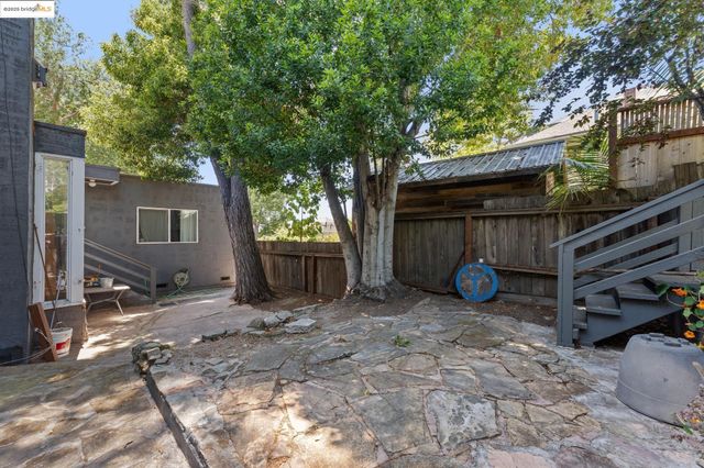a view of a house with a backyard and a tree