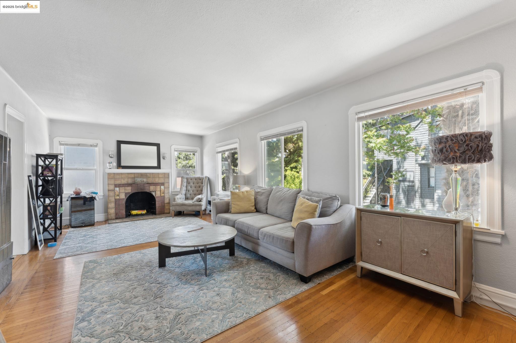 2823 11th Avenue, Unit B Oakland, CA 94610 - Photo 2 of 12 a living room with furniture large window and fireplace