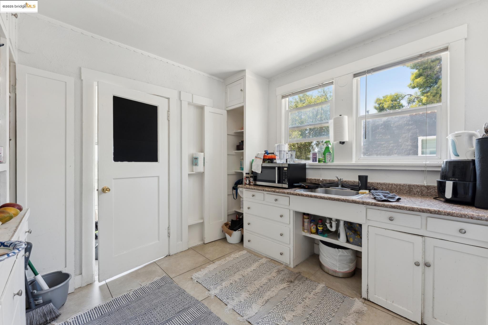 2823 11th Avenue, Unit B Oakland, CA 94610 - Photo 4 of 12 a kitchen with a sink cabinets and window