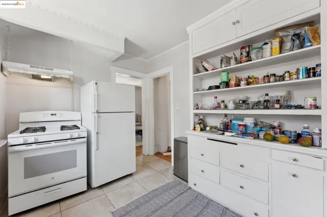 a kitchen with stainless steel appliances white cabinets and wooden floors