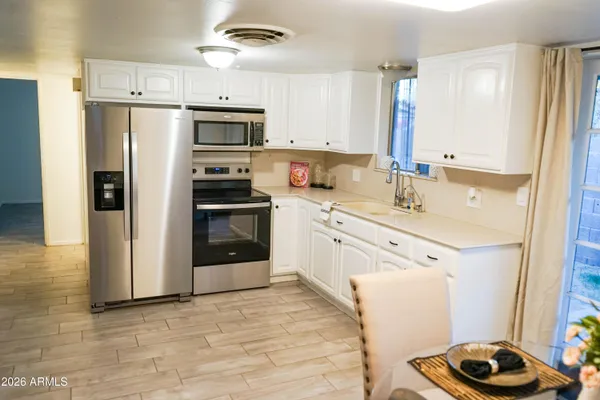 a kitchen with stainless steel appliances granite countertop a refrigerator and a stove