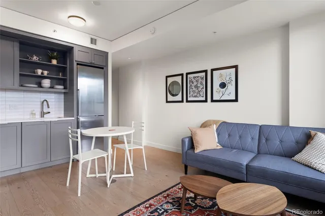 a living room with furniture a rug and kitchen view