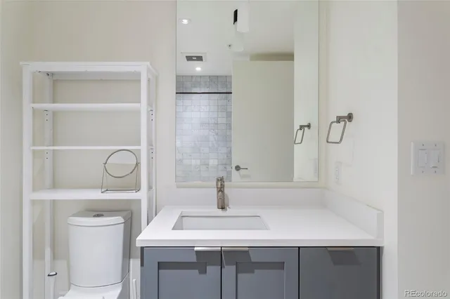 a bathroom with a sink toilet vanity and tub